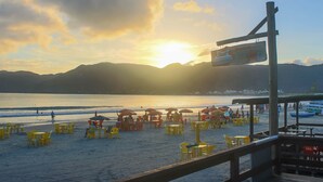 A beachside restaurant with outdoor seating and a view of the ocean. - Pousada Estrelas no Mar (Florianópolis)