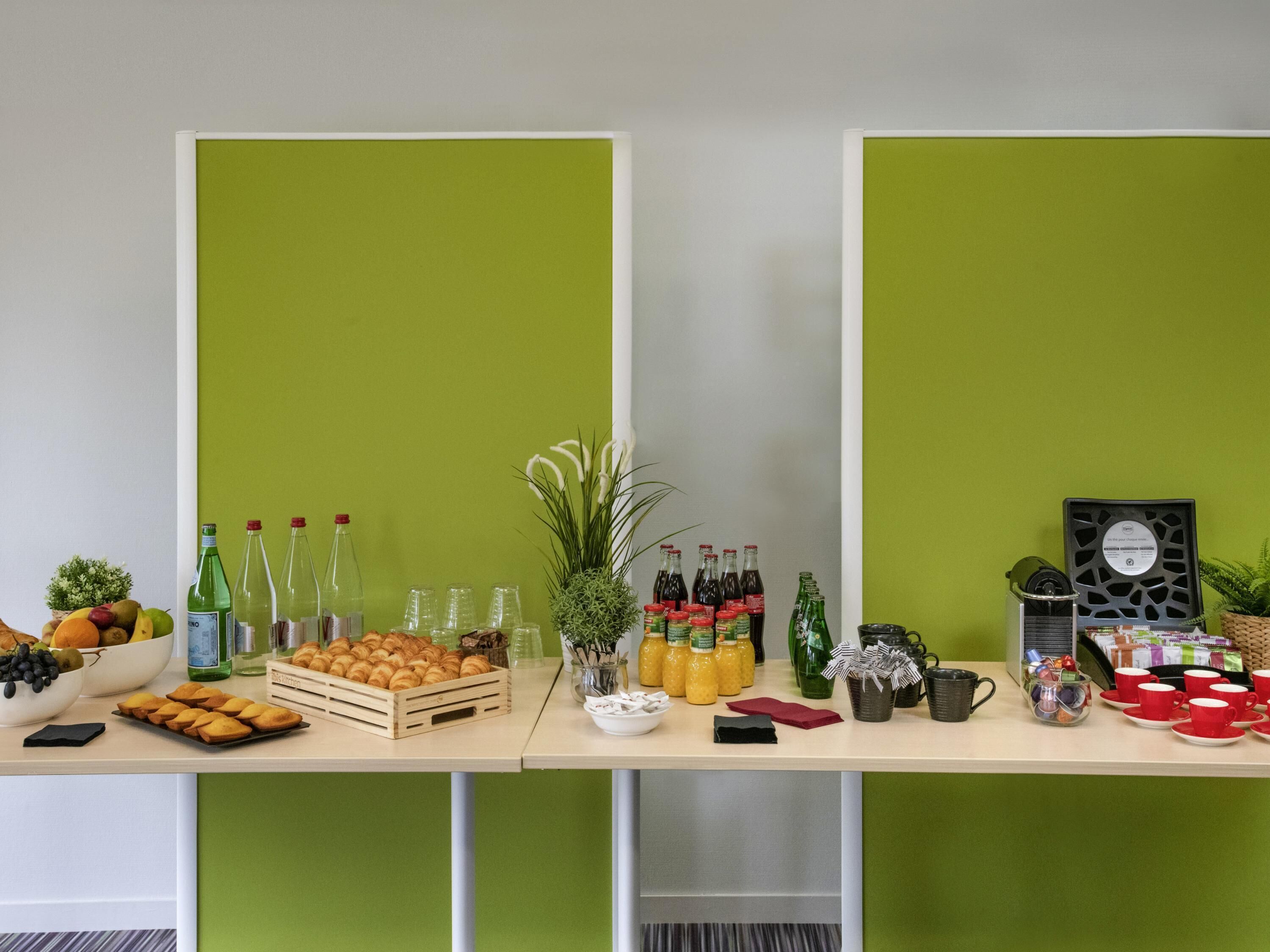 A buffet table with various food items, drinks, and a coffee machine.