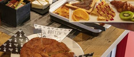 A breakfast buffet with various food items and a sign reading "BREIZH".