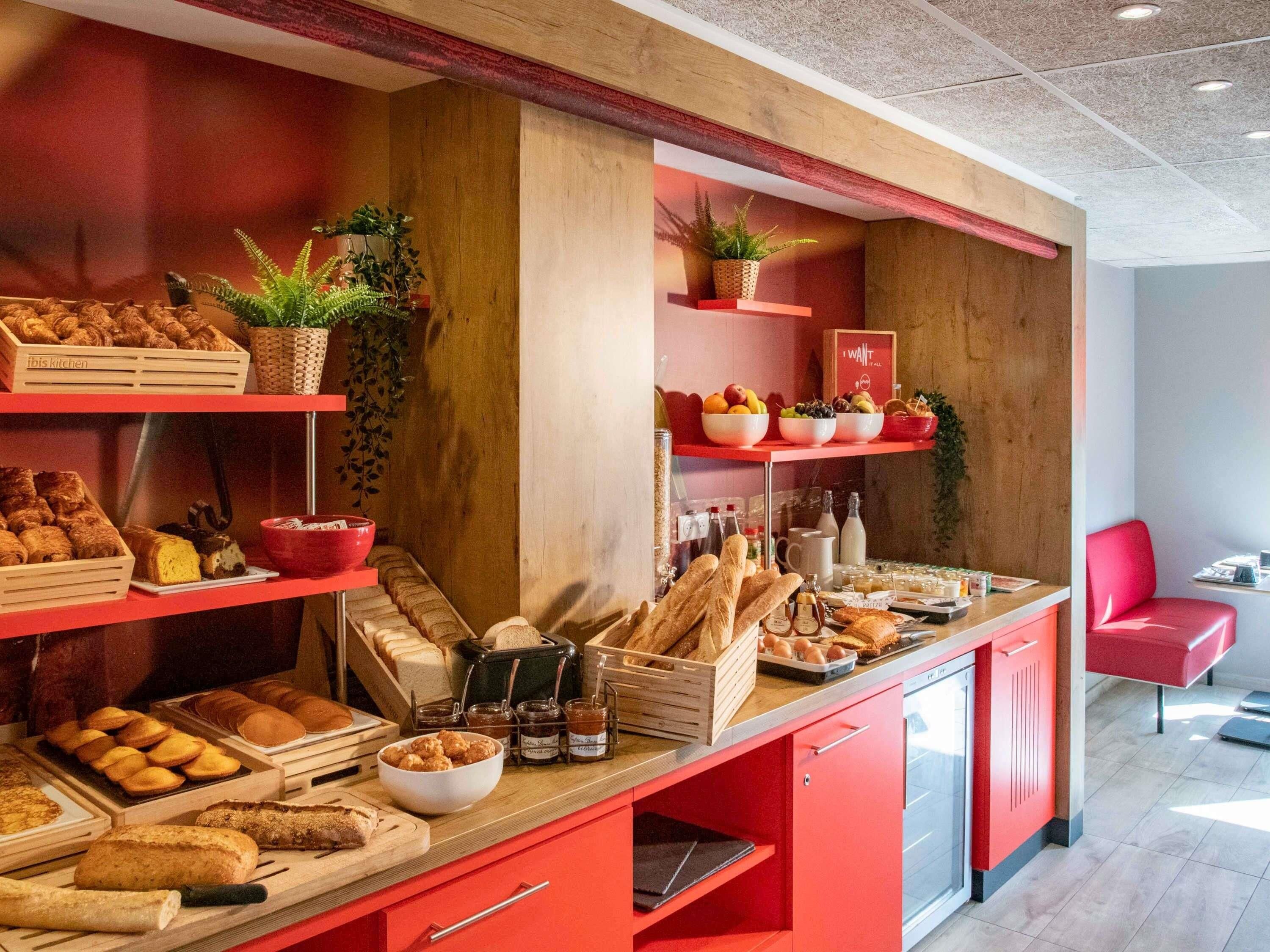 Un bufé de desayuno con panes, pasteles y frutas variados.