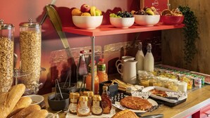 A breakfast buffet with various food items, including bread, eggs, and fruits.