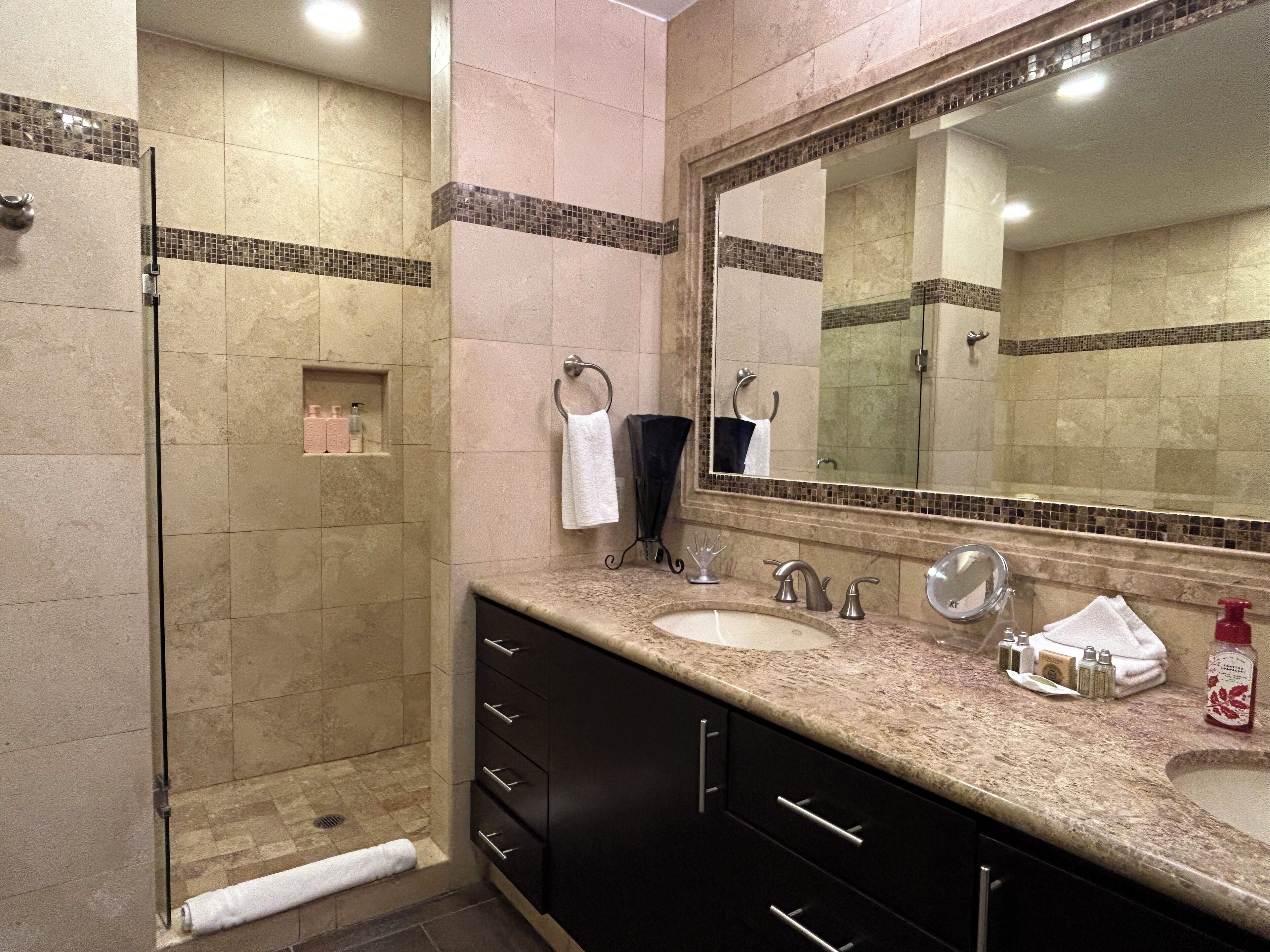 Une salle de bain avec une douche, un lavabo et un meuble-lavabo.