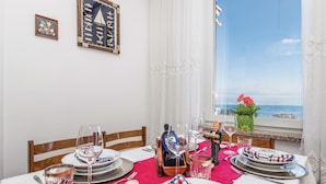 A dining table set for two with a view of the sea.