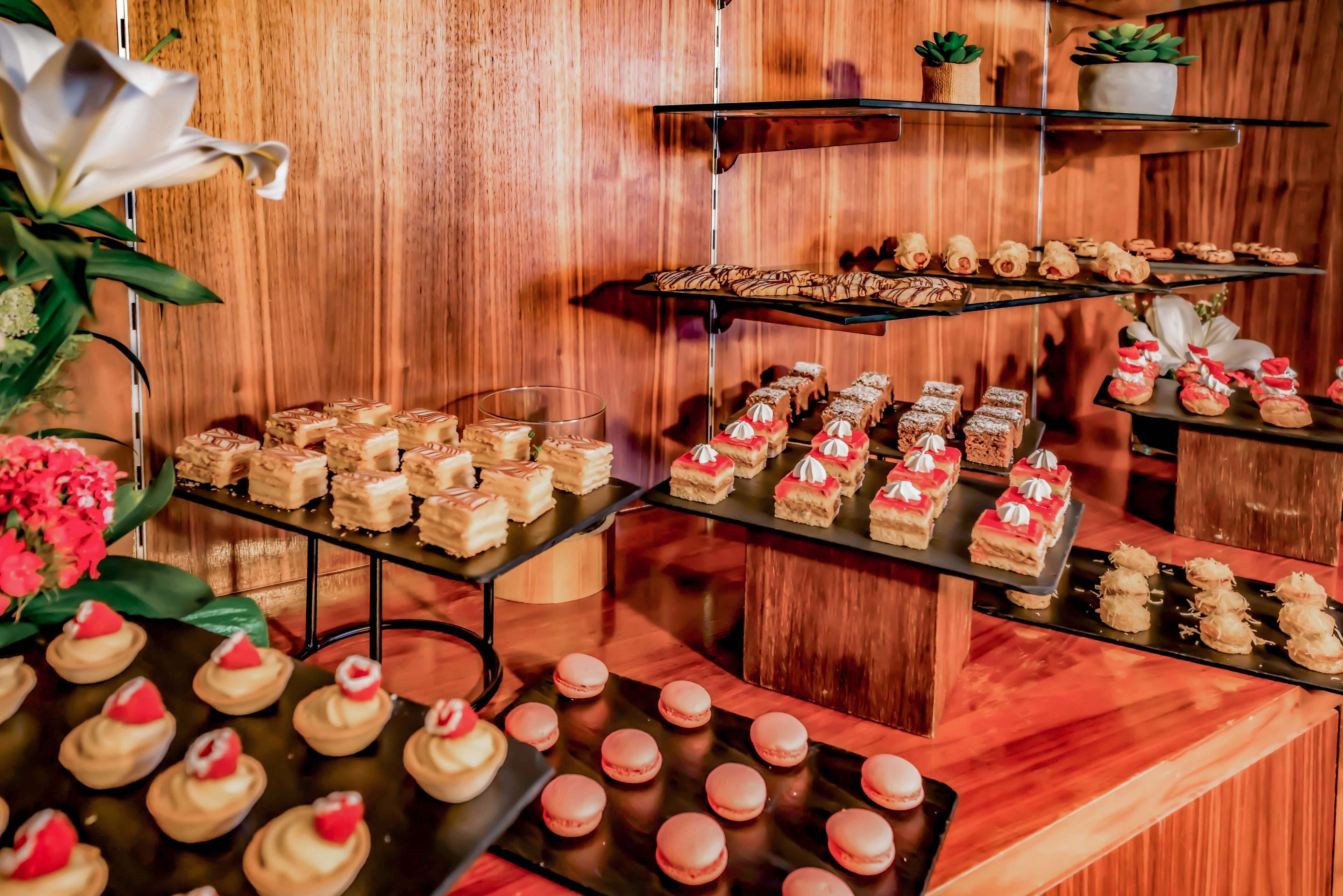 Een dessertbuffet met diverse gebakjes en desserts, gepresenteerd op meerdere etagères.