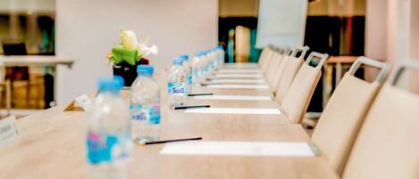 A conference table with water bottles and nameplates, indicating a meeting setup in a hotel room.
