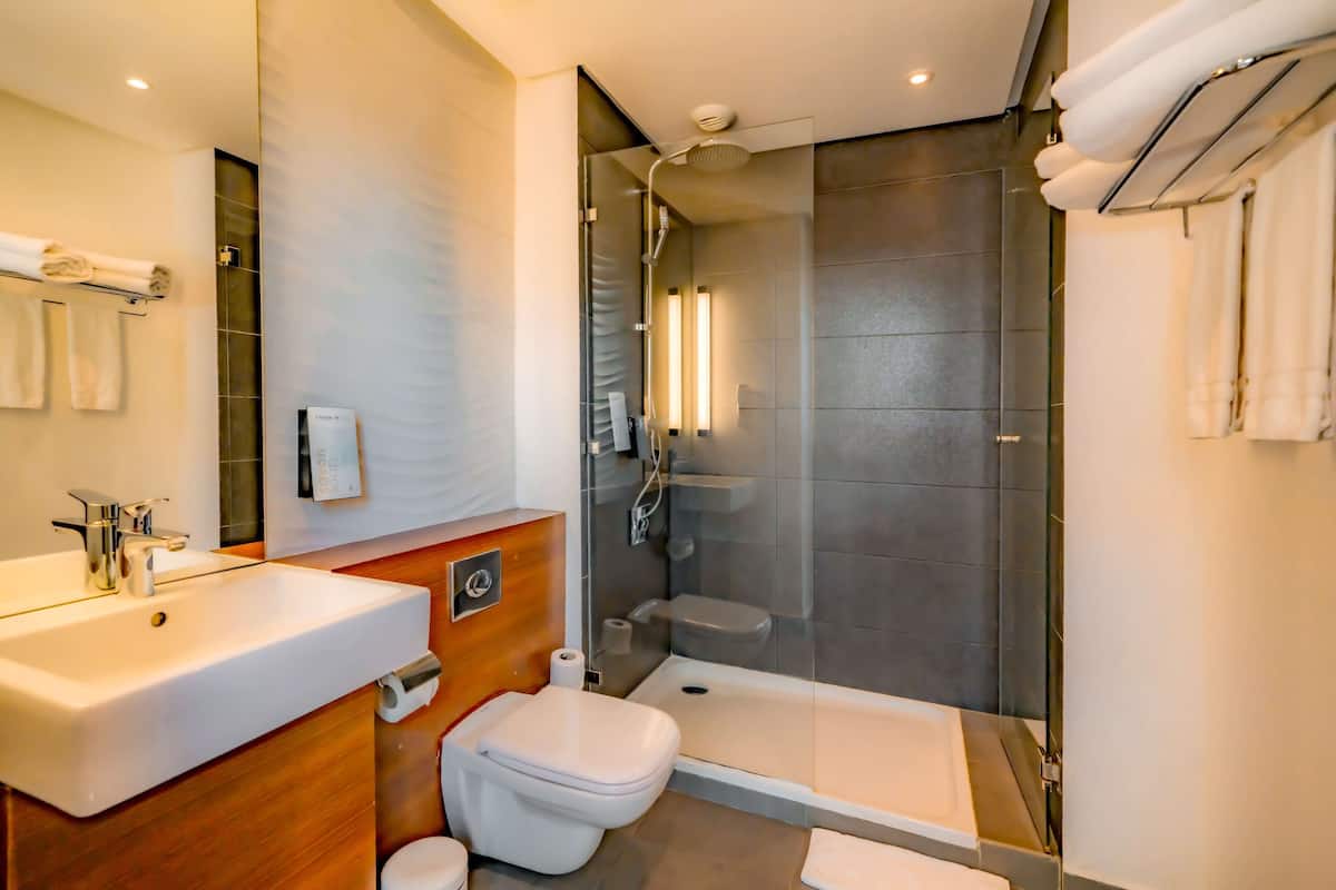A modern bathroom with a sink, toilet, and glass-enclosed shower.
