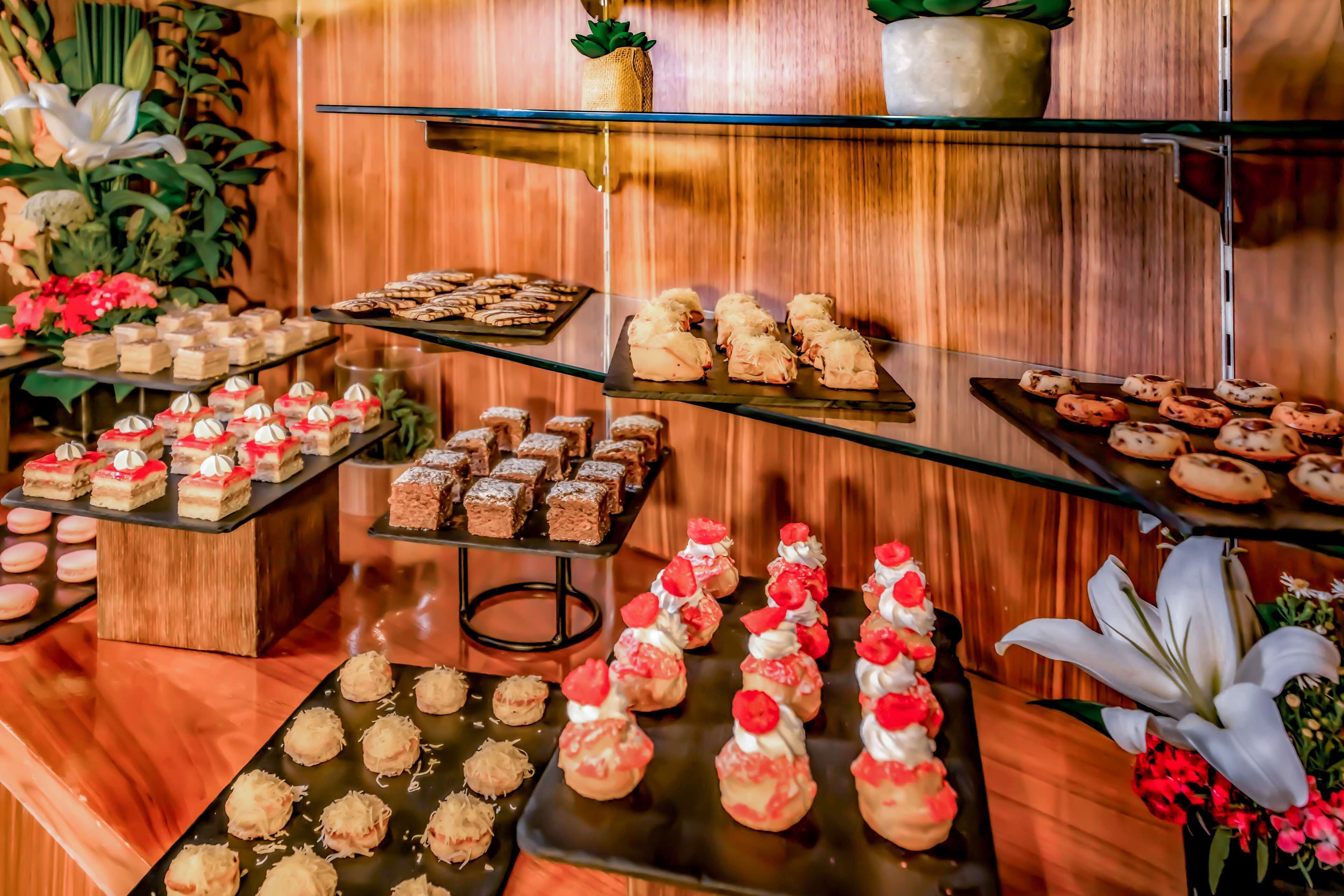 A buffet with various desserts and pastries on multiple serving platters.