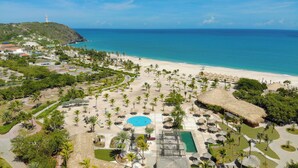 An aerial view of a resort with a beach, a swimming pool, and a lighthouse in the background. - Sunsol Ecoland (Matasiete)