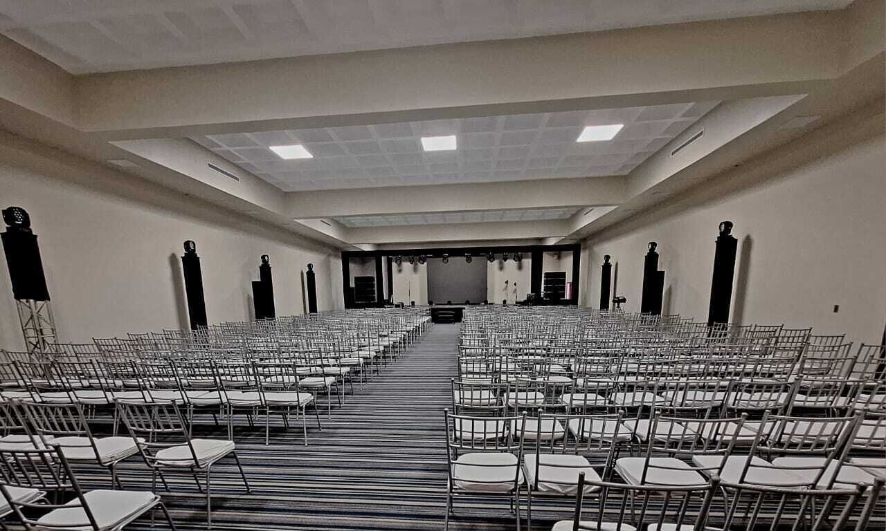 Una sala conferenze con file di sedie rivolte verso un palco.