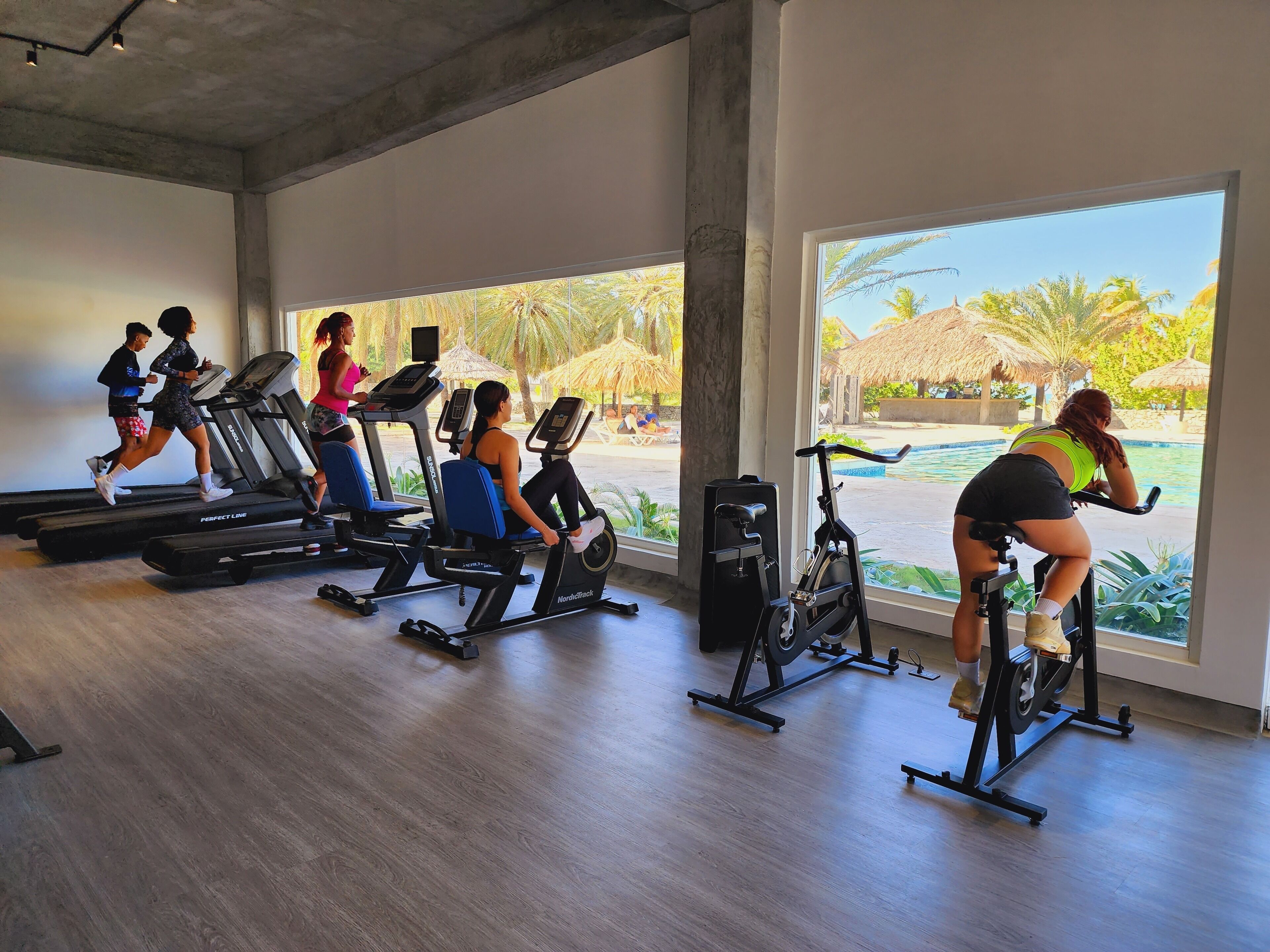 A gym with treadmills, stationary bikes, and elliptical machines.