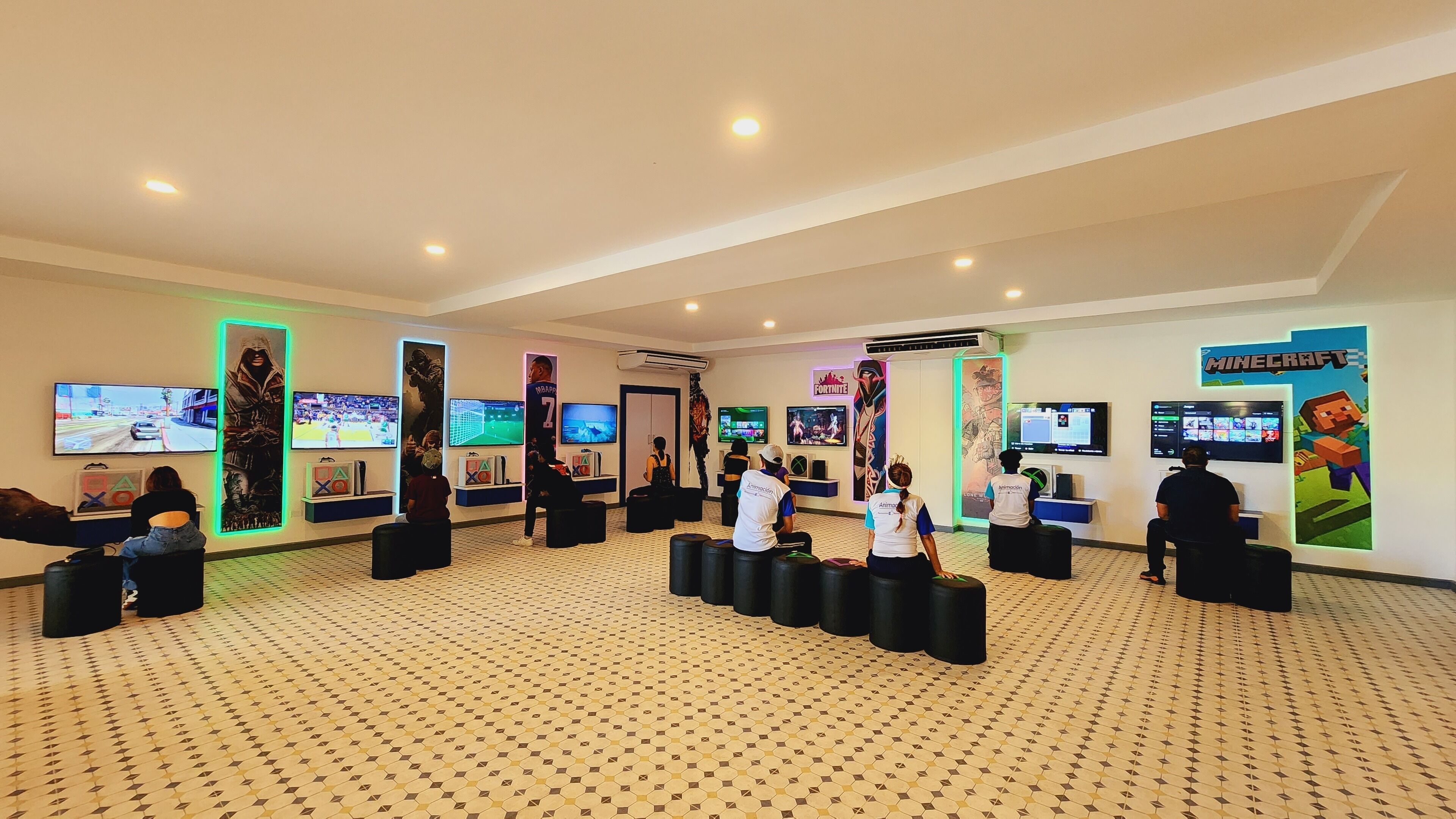 A gaming lounge with multiple gaming stations, comfortable seating, and large screens displaying various games.