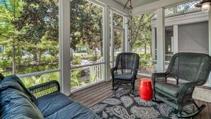 A covered porch with wicker furniture, a red barrel, and a patterned rug. - WaterColor Home with 6-Passenger Electric Cart, 4 Bikes & Beach Club Access (Seagrove Beach)