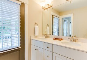 A bathroom with a large mirror, two sinks, and a window with blinds. - Spacious 4 BR Townhouse Walking Distance to the Beach and Boardwalk  (412B) (Virginia Beach)