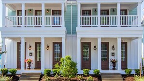 A two-story house with a front porch, a central chimney, and a symmetrical facade.