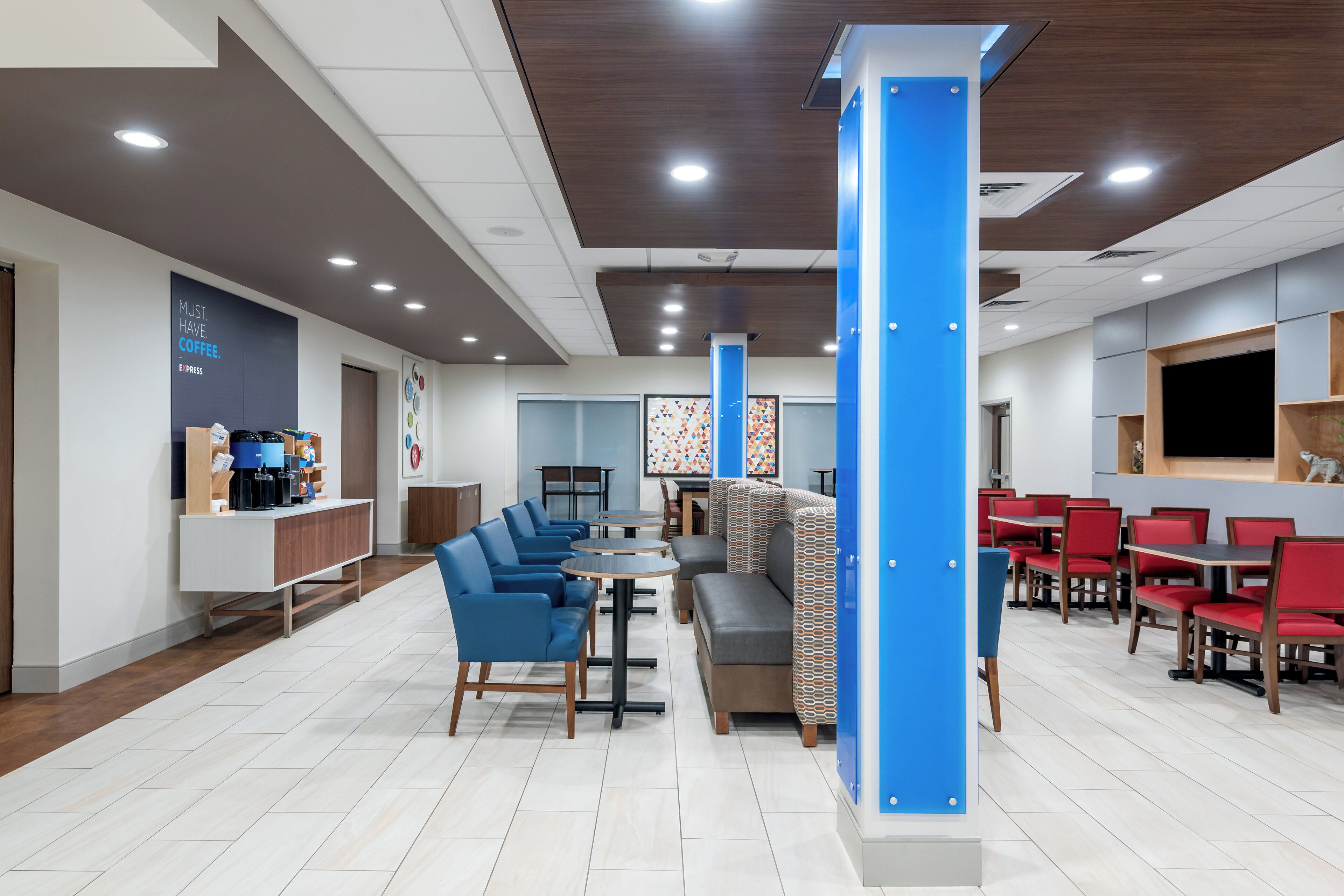A modern cafe with seating areas, a coffee station, and a counter.