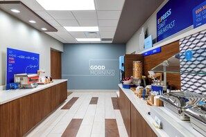 A breakfast area with a sign reading 'GOOD MORNING' and a counter with food items and a coffee machine. - Holiday Inn Express & Suites Punta Gorda by IHG (Punta Gorda)