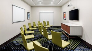 A conference room with a projector screen, a flat-screen TV, and a carpeted floor. - Holiday Inn Express & Suites Punta Gorda by IHG (Punta Gorda)