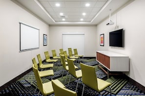 A conference room with a projector screen, a flat-screen TV, and a carpeted floor. - Holiday Inn Express & Suites Punta Gorda by IHG (Punta Gorda)