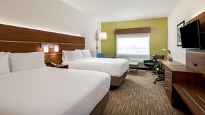 A hotel room with two beds, a desk, a chair, a TV, and a window with a city view.