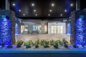 A building entrance with a stone facade, a bench, and a water feature. - Holiday Inn Express & Suites Punta Gorda by IHG (Punta Gorda)