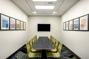 A conference room with a long table, yellow chairs, framed artwork on the walls, and a flat-screen TV mounted on the wall. - Holiday Inn Express & Suites Punta Gorda by IHG (Punta Gorda)