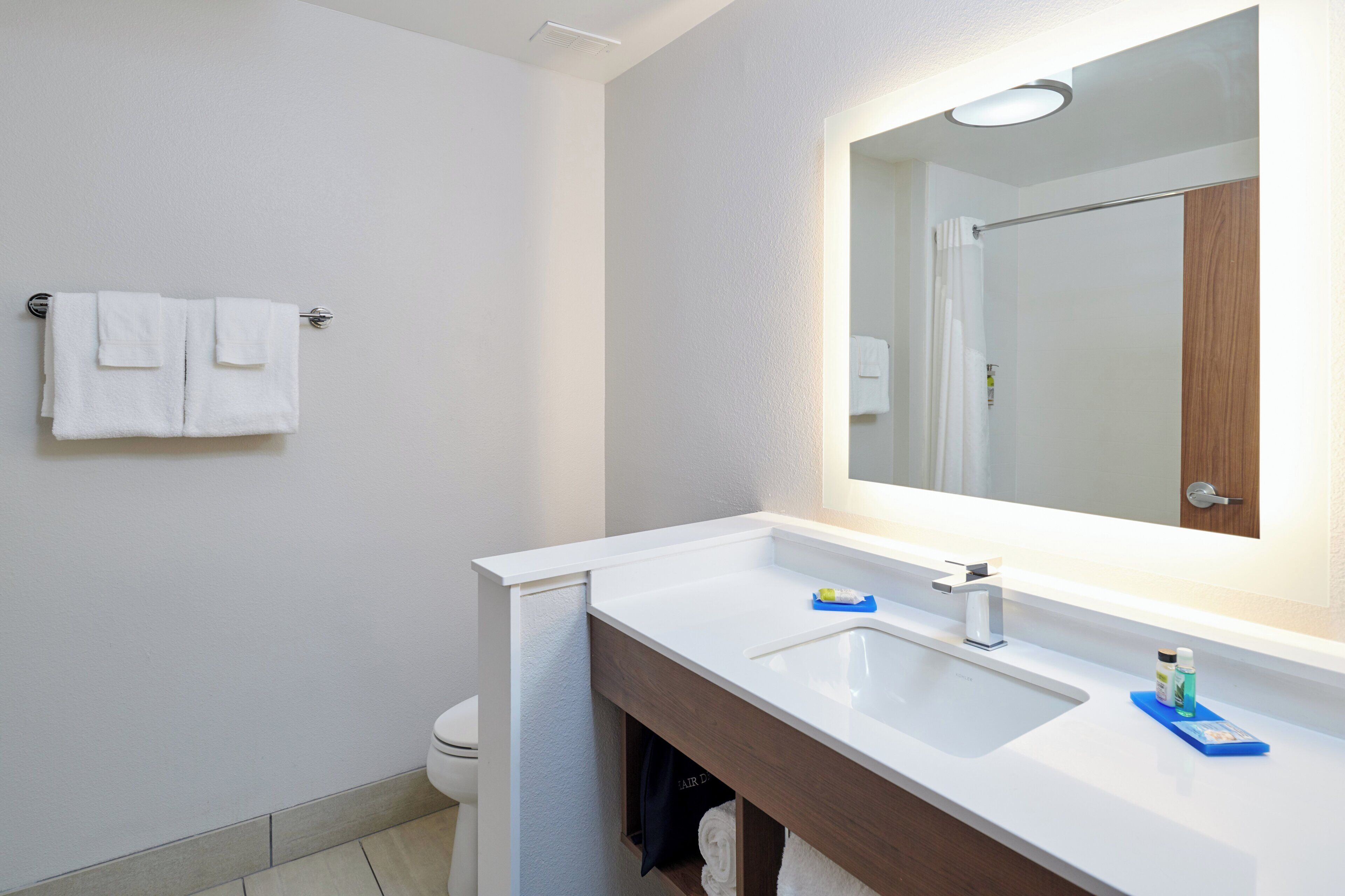 A bathroom with a white sink, a mirror, and a towel rack.