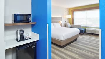 A hotel room with a bed, a microwave, a coffee maker, and a window with a view.