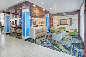 A hotel lobby with a seating area, a reception desk, and a dining area. - Holiday Inn Express & Suites El Paso East-Loop 375 by IHG (El Paso)