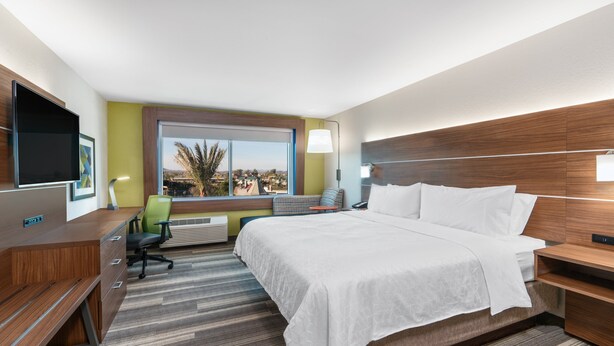 Ein Hotelzimmer mit Bett, Schreibtisch, Stuhl und Fernseher.