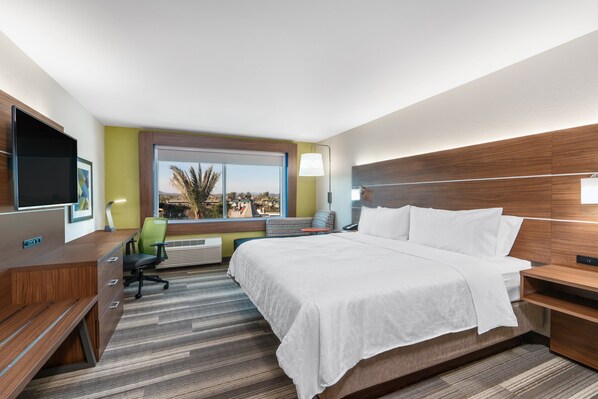 Une chambre d’hôtel équipée d’un lit, d’un bureau, d’une chaise et d’un téléviseur.