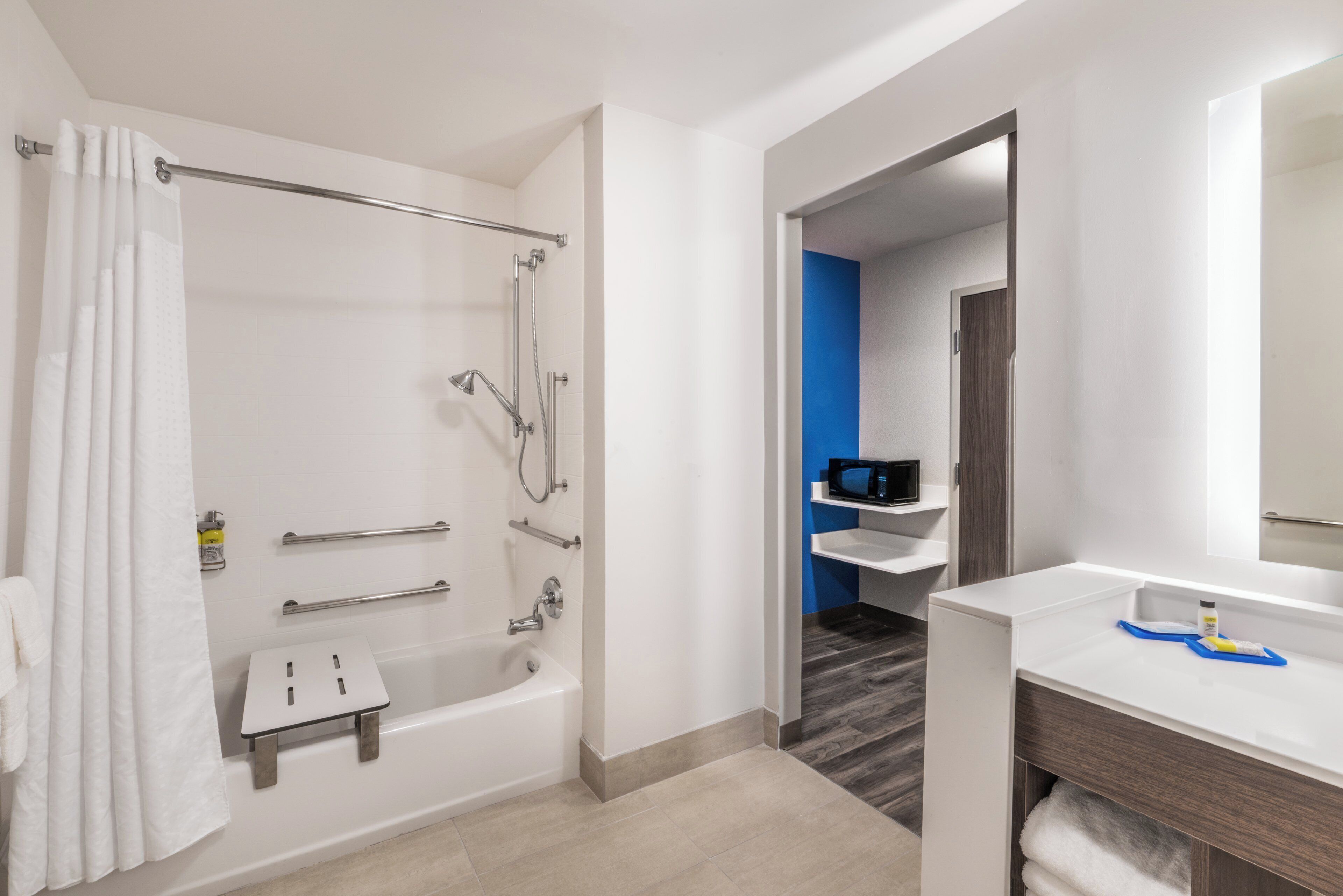 A modern bathroom with a bathtub, shower, and vanity.