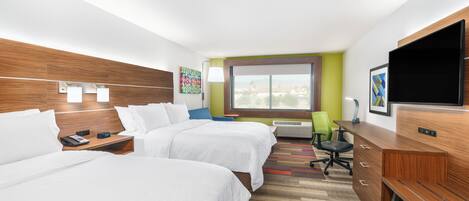 A hotel room with two beds, a desk, a chair, a TV, and a window with a view.