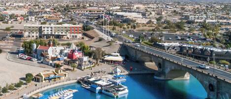 A coastal town with a marina, a bridge, and mountains in the background.