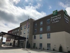 A Holiday Inn Express building with a stone facade, multiple windows, and an American flag.