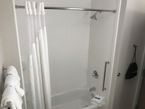 A modern bathroom with a glass-enclosed shower, a towel rack, and a black bag hanging on the wall. - Holiday Inn Express & Suites Hannibal - Medical Center by IHG (Hannibal)