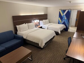 A hotel room with two beds, a blue sofa, a wooden table, and a desk. - Holiday Inn Express & Suites Hannibal - Medical Center by IHG (Hannibal)