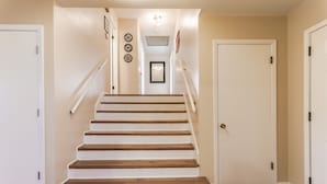 Una escalera que conduce a una puerta con una lámpara colgante encima.