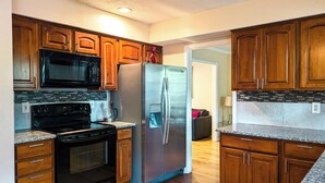 Una cocina moderna con armarios de madera, electrodomésticos de acero inoxidable y encimera de granito.