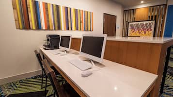 Zona de recepción de un hotel con un mostrador largo, dos monitores, una impresora y un teclado.