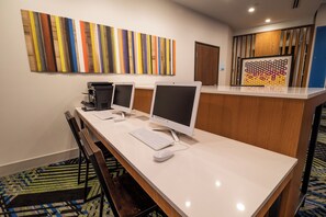 Ein Hotel-Rezeptionsbereich mit einer langen Theke, zwei Bildschirmen, einem Drucker und einer Tastatur.