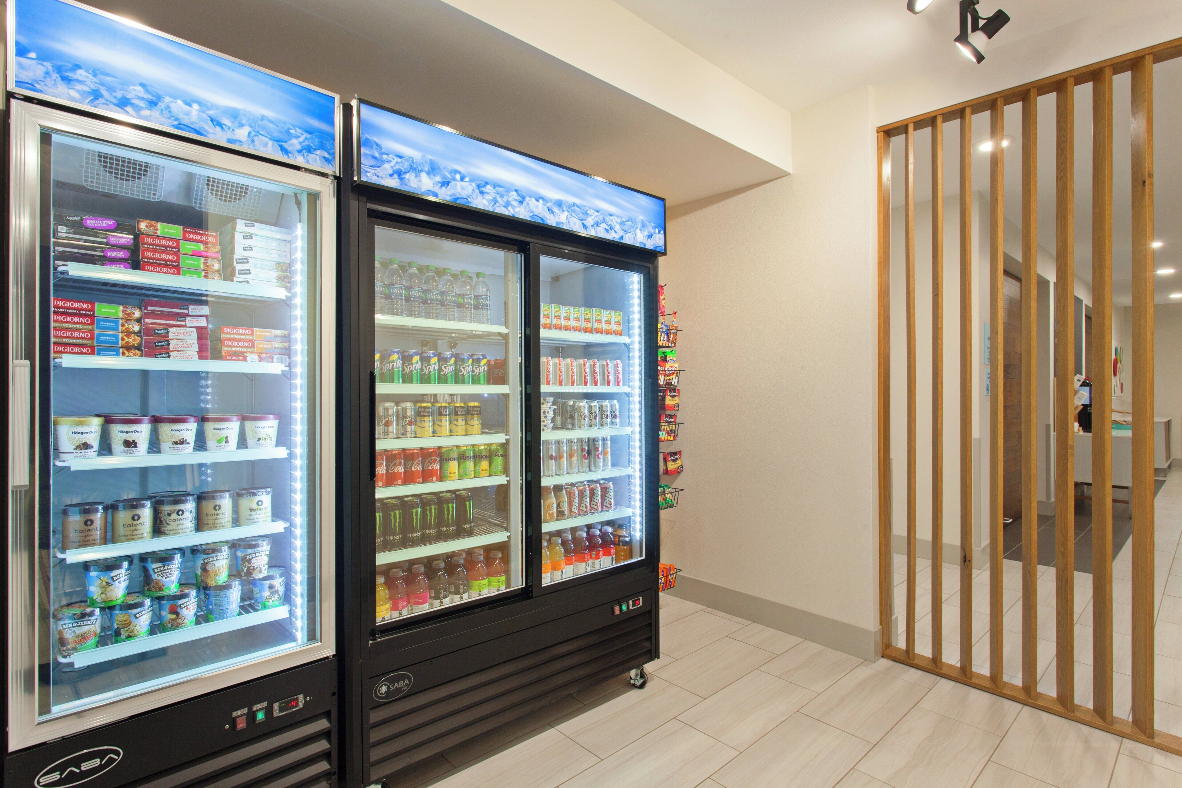 A vending machine area with refrigerated units stocked with beverages and snacks.
