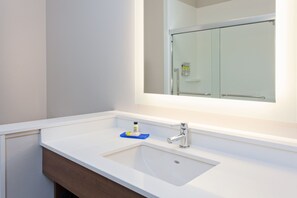 A bathroom with a white sink, a mirror, and a glass shower door. - Holiday Inn Express & Suites Moses Lake by IHG (Moses Lake)