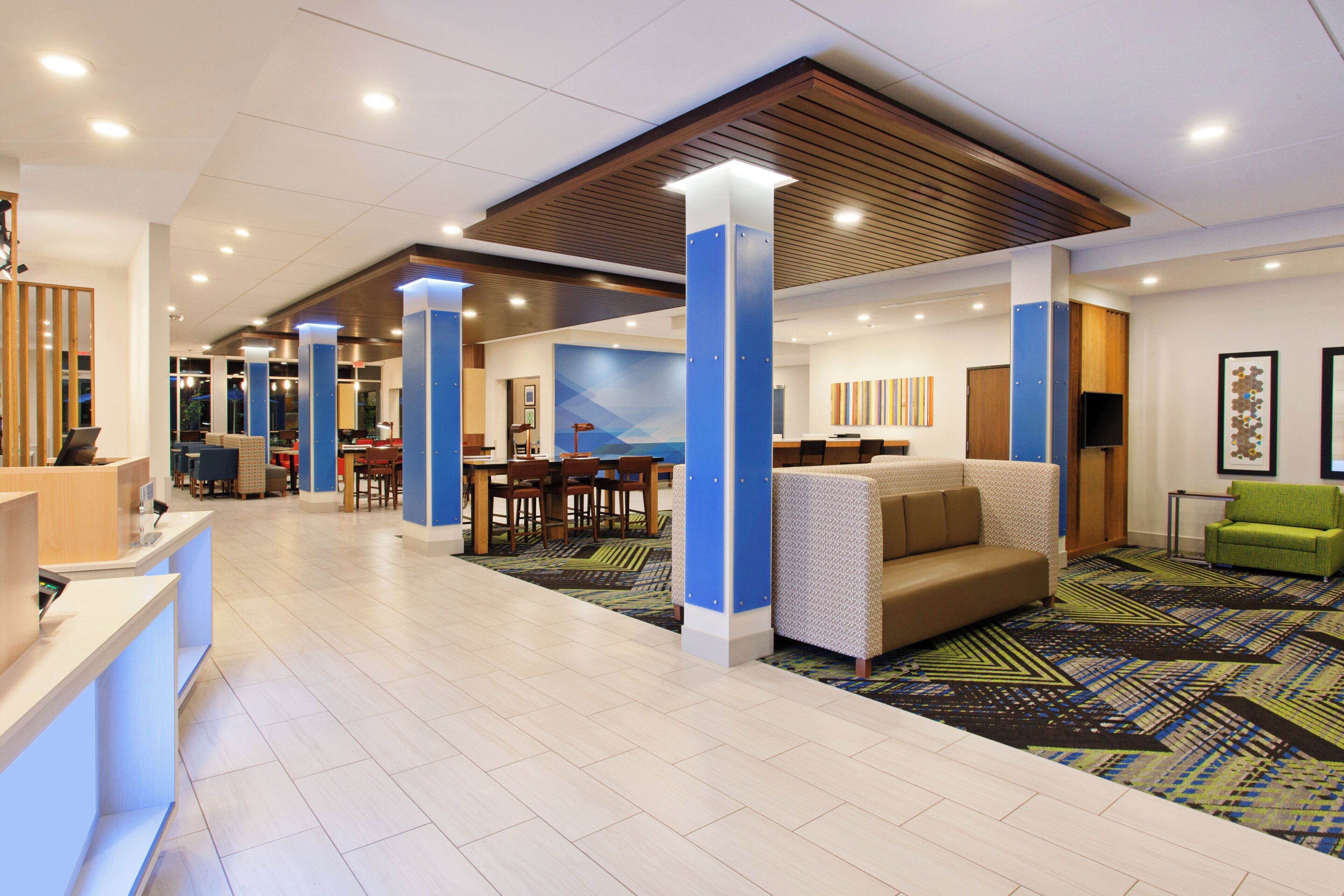 A spacious lobby with a reception desk, seating area, and a large wall mural.