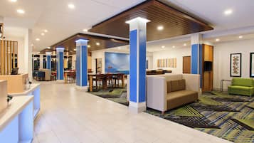 A spacious lobby with a reception desk, seating area, and a large wall mural.