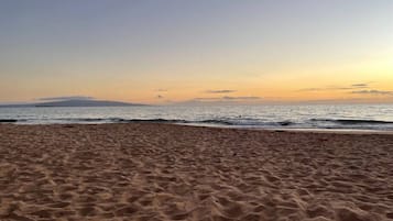 A sandy beach with gentle waves and a clear sky.