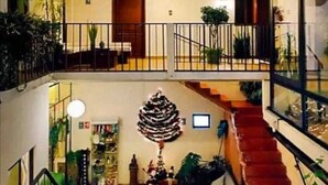 Un edificio residencial de varios niveles con escaleras, balcones y plantas de interior.
