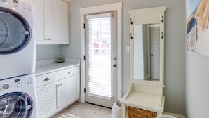 A laundry room with a washing machine, a dryer, a vanity with a mirror, and a chandelier. - 2BR Virginia Beach townhouse with king suite, balcony, WiFi, parking. (Virginia Beach)