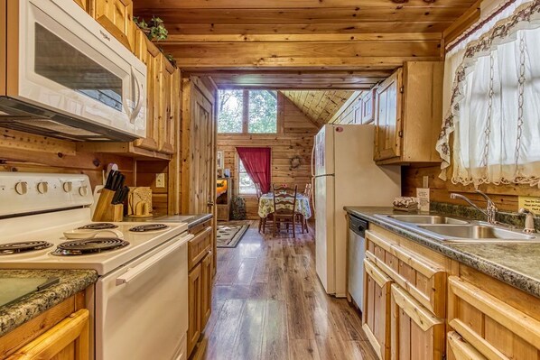 Enjoy meals in the kitchen with a central island and dining area, featuring a stove, microwave, refrigerator, and wooden cabinets.