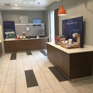 A modern kitchen area with a bakery section, a coffee machine, and a sign indicating a bakery. - Holiday Inn Express and Suites Nebraska City by IHG (Nebraska City)