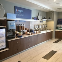 Un espacio para desayunar con cafetera, dispensadores de cereales y un letrero que dice 'EXPRESS START BREAKFAST'.